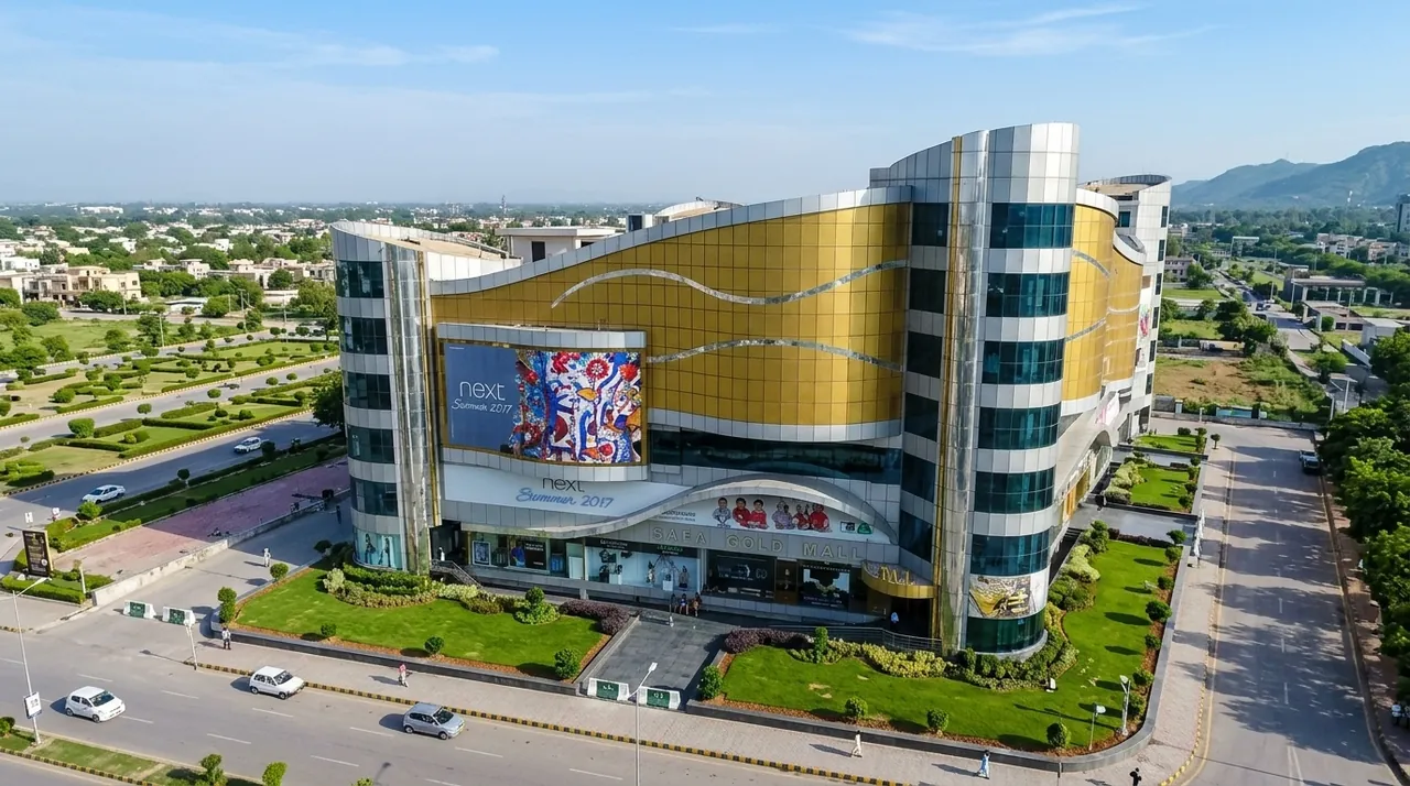 Safa Gold Mall in F-7 Islamabad seen from above with gold glass facade and the Margalla hills behind